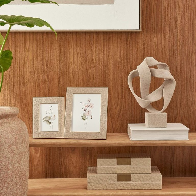 Sala decorada com porta retrato e escultura com linhas limpas e volumes